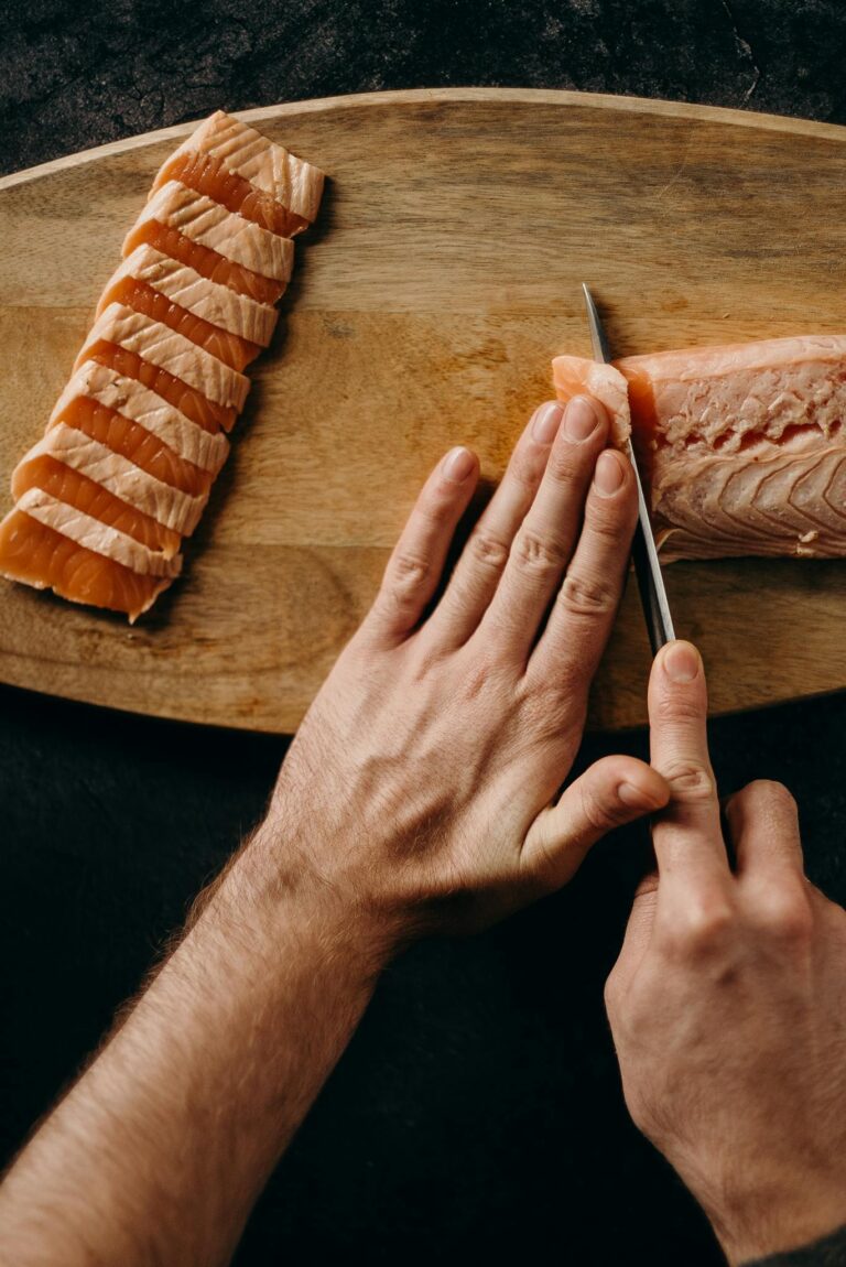 Person Holding Bread on Brown Wooden Chopping Board